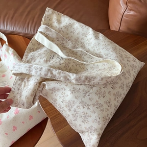 Close-up of vintage floral canvas tote bag featuring brown botanical prints and woven label