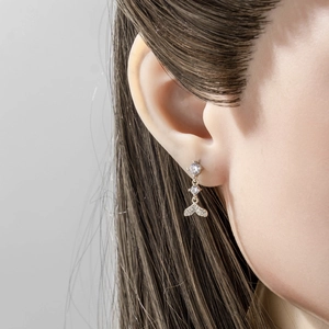 Elegant silver mermaid tail piercing earring with sparkling zircons worn by a model