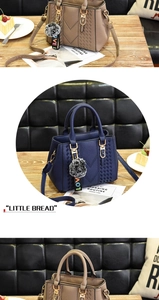 Detail of lychee pattern synthetic leather handbags with soft grey pompom charm
