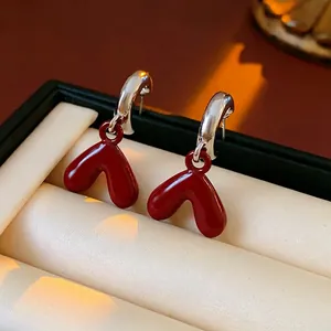 Elegant red heart-shaped drop oil earrings with silver needles in a jewelry box