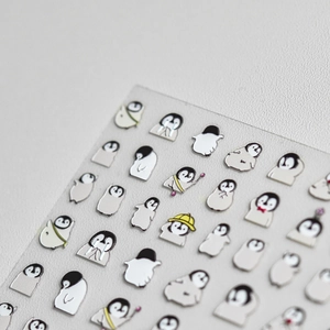 Détail macro de stickers 3D gaufrés pour ongles motif pingouin avec texture argentée