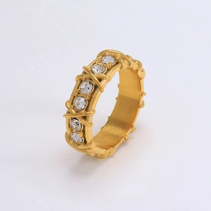 Elegant gold crossover ring featuring a woven design and clear crystal inlay on white background