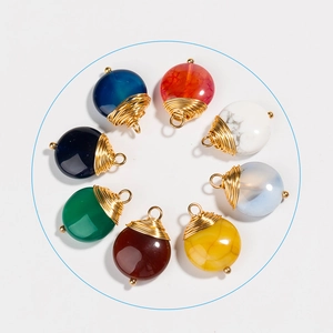 Pendentifs en pierres naturelles multicolores avec fil doré sur un fond blanc pur
