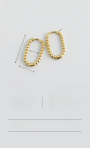 Macro shot of S925 sterling silver U-shaped gold earrings with beaded chain texture