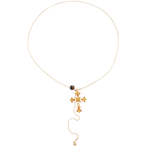 Retro gold cross necklace with yellow crystals and a brown bead on a white background