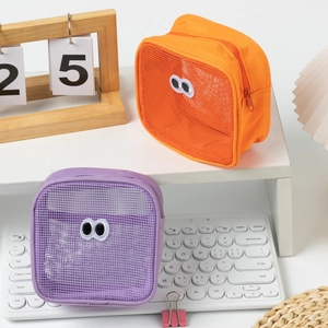 Detail of cute mesh makeup pouches in orange and purple with large embroidered eyes