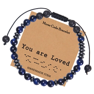 Detail of Morse Code bracelet with tiger eye stones and lava beads on display card