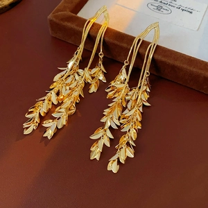Detailed view of long gold leaf tassel earrings with a luxurious polished metallic finish