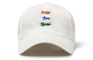 Detail of white breathable baseball cap featuring three-color letter embroidery and eyelets
