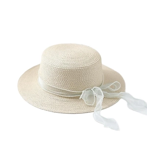 Elegant beige straw boater hat featuring white lace tulle ribbon and delicate pearls