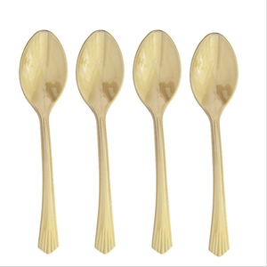 Detailed view of four beige plastic spoons with scalloped handle texture for party