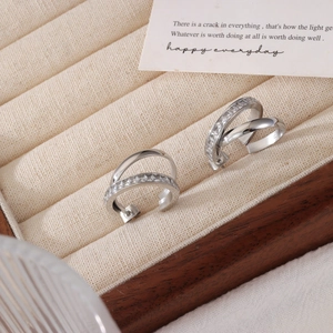 Double-layered silver hoops with cubic zirconia stones displayed on a beige jewelry box