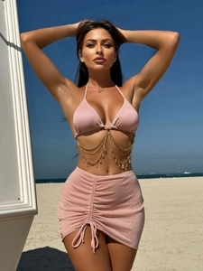 Detail of pink glitter bikini set with metallic chains and water-drop beads on beach