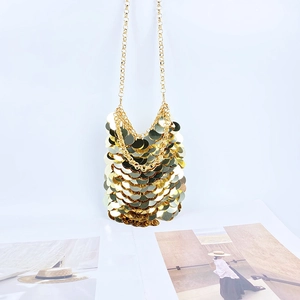Detail shot of a golden sequin mini crossbody bag with a delicate metal chain strap