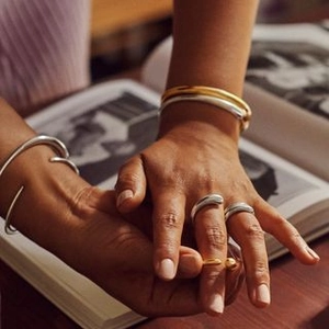 Nahaufnahme eines Models mit modischen stapelbaren Titanstahlringen in Gold und Silber