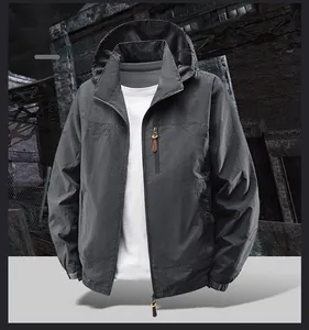 Detail der grauen Outdoor-Herrenjacke mit Reißverschlusstasche und Berg-Logo-Stickerei