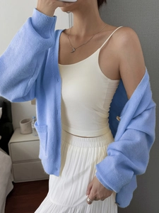 Women's blue knit cardigan with beige camisole and pleated skirt for autumn vacation look