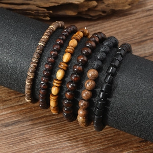 Macro shot of layered men's wooden beads and coconut shell bracelets on a black display stand
