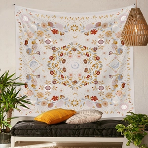 Close-up of bohemian tapestry with floral sun and moon motifs hanging on a home wall