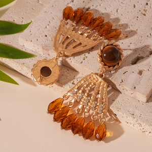Macro view of gold vintage earrings with tiger eye stone, rhinestones and amber crystal beads