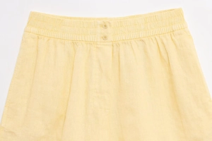 Détail du short en coton et lin jaune clair avec taille élastique et double boutonnage