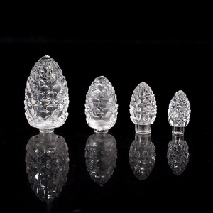 Set of four transparent pinecone-shaped LED light covers in varied sizes on a black background