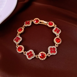 Gros plan détaillé du bracelet vintage doré avec pierres rouges et strass blancs