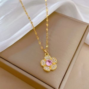 Detail of flower pendant with pink gemstone and pavé crystals on gold titanium chain