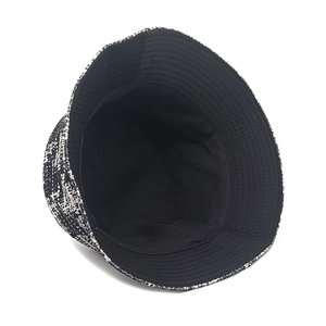 Detailed view of black and white houndstooth bucket hat with warm inner lining