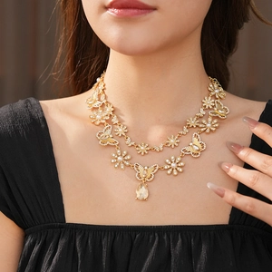 Détail d'un collier papillon doré à deux rangs avec strass et pendentif en goutte d'eau