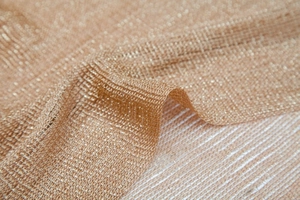 Close-up of golden metallic mesh fabric showing detailed weave and silky texture