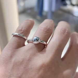Hand wearing a minimalist 925 sterling silver ring with a polished ball accent