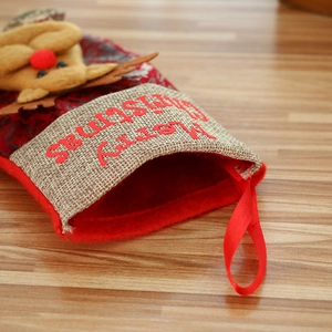 Vintage red Christmas stocking with beige cuff and reindeer embroidery hanging on tree