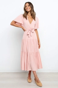 Detalle de vestido cruzado rosa claro con mangas de volantes y falda a capas
