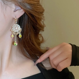 Detailed view of iridescent crystal drop earrings with vintage flower design on model