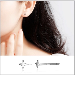 Macro detail of S999 sterling silver star stud earring with hallmark and ear placement