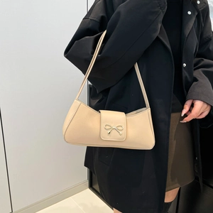 Minimalist beige PU leather underarm baguette bag with a golden bow metal buckle detail
