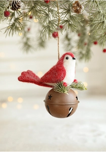 Detail of knitted bird ornament and vintage metal bell hanging on a Christmas tree branch