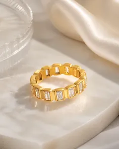 Détail macro d'une bague dorée minimaliste sertie de zircons rectangulaires en rail