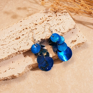 Vue détaillée de boucles d'oreilles géométriques en nacre bleue sur pierre naturelle