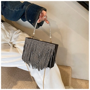 Detail of black rhinestone evening bag with sparkling diamond handle and gold chain strap