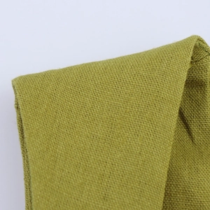 Close-up detail of green cotton linen fabric texture with premium weave for long dresses