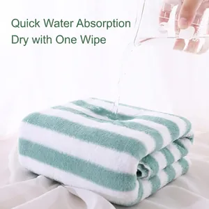 Absorbent green and white striped coral fleece towel set demonstrating fast water absorption