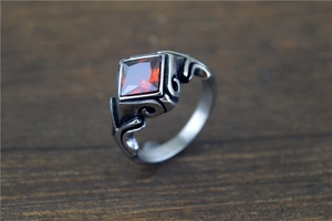 Macro detail of vintage stainless steel ring with red gemstone and antique silver finish