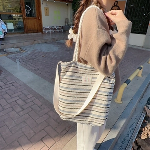 Detailed close-up of colorful striped canvas tote bag with sozakka embroidery label
