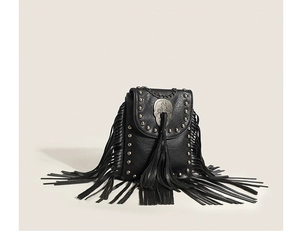 Close-up of black fringe crossbody bag with metal studs, skull charm and chain strap
