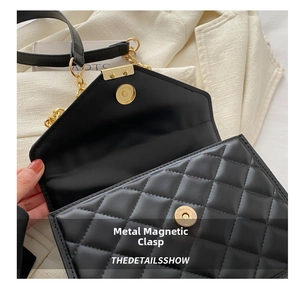 Close-up of black quilted PU leather shoulder bag with gold metal magnetic closure