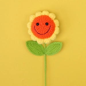 Gros plan sur une poupée tournesol au crochet faite main avec visage souriant
