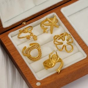 5-piece gold starfish and mermaid tail open ring set displayed on white velvet
