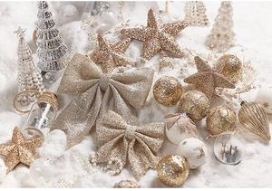 Macro shot of assorted gold and silver Christmas ornaments with glitter on artificial snow